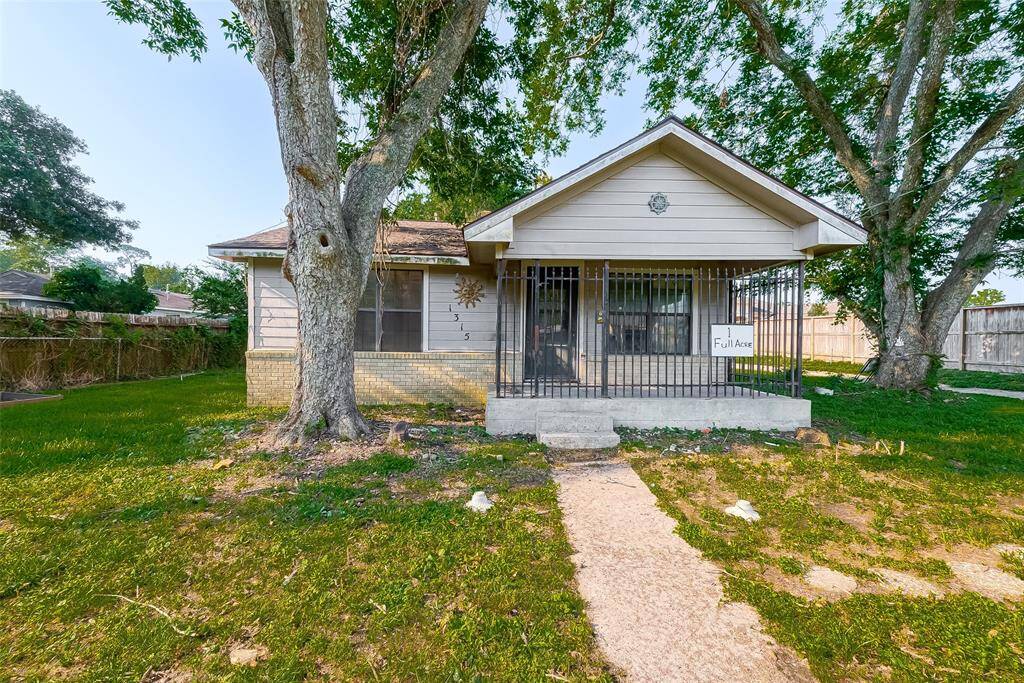 Single-family home (needs work) nestled on a spacious lot with mature trees.