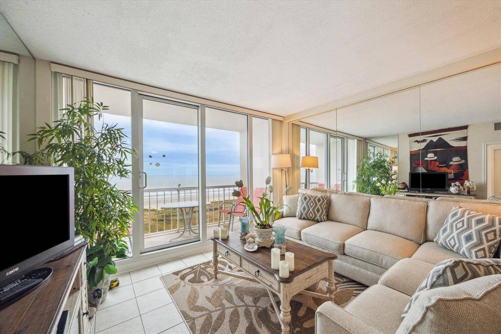 Living area enjoys floor-to-ceiling windows and door overlooking the Gulf.