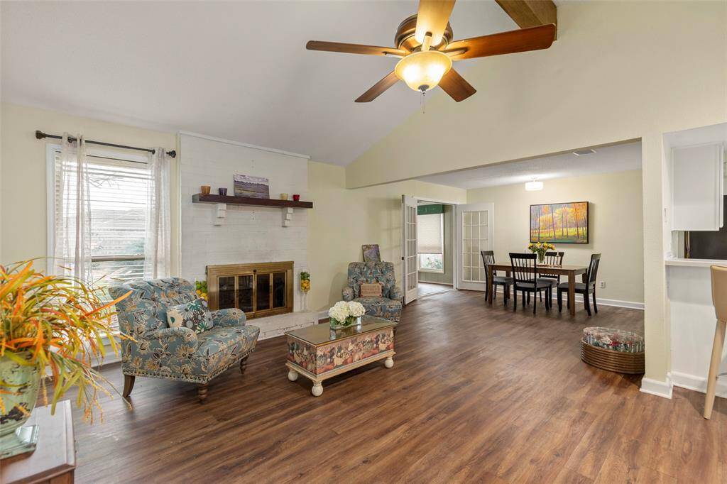Lovely living area with brick surround wood burning fireplace, ceiling fan with light, views to the landscaped backyard. Opens nicely to the dining area.