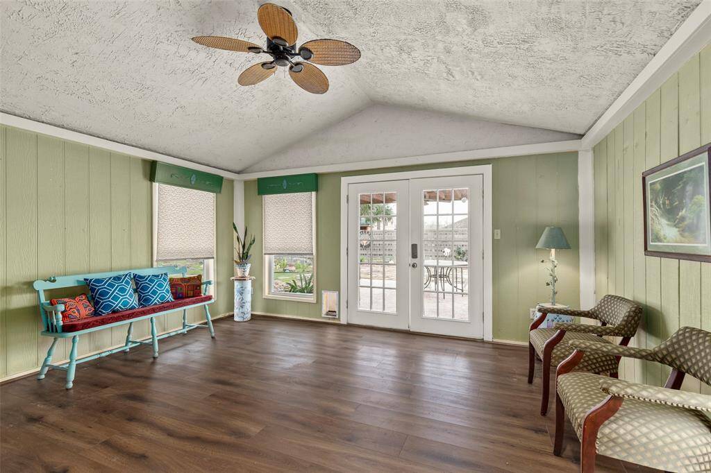 Sunroom with vaulted ceilings, ceiling fan and French doors to the patio/professionally landscaped back yard.