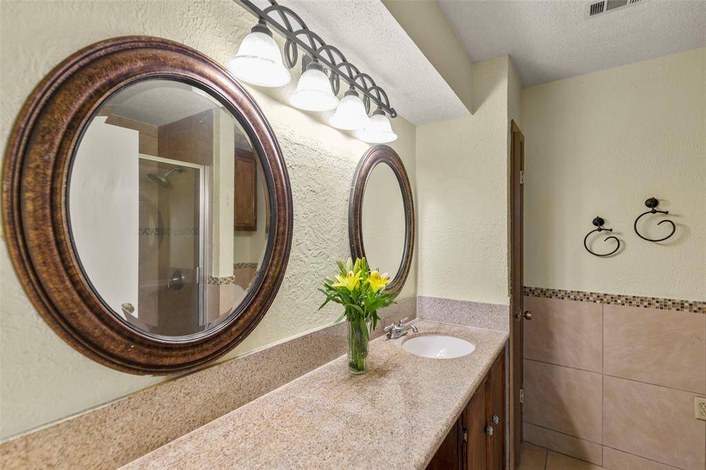 Ensuite primary bathroom features vanity and walk-in shower.