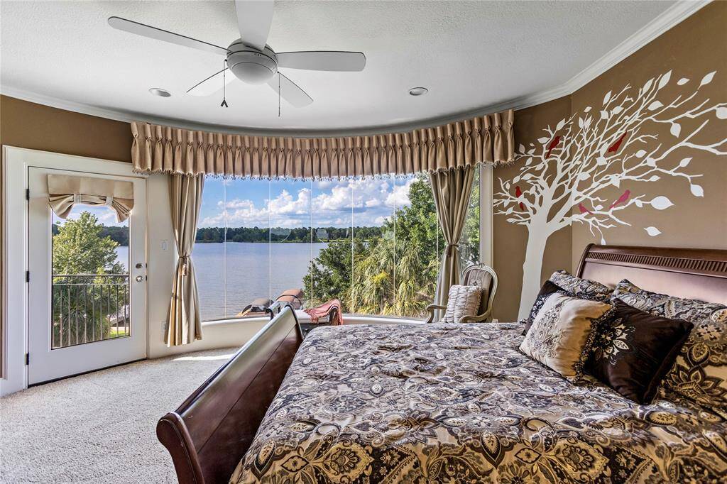 This bedroom offers a serene lake view with a walk-out balcony, all complement with the butted glass with an abundance of natural light.