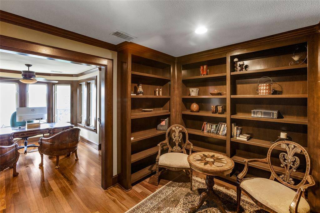 This 4th floor library featuring floor to ceiling rich wooden built-in bookshelves. Natural light streams in from ample windows and balcony.