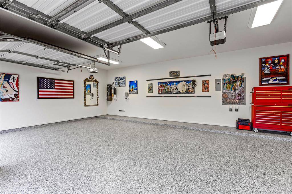 This is a spacious, 3 car garage with oversized work space and with an epoxy-coated floor, featuring ample space and utility sink.