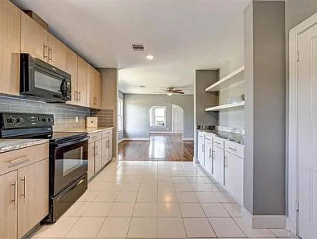 This angle shows how the layout of the kitchen flows into the bright family room.