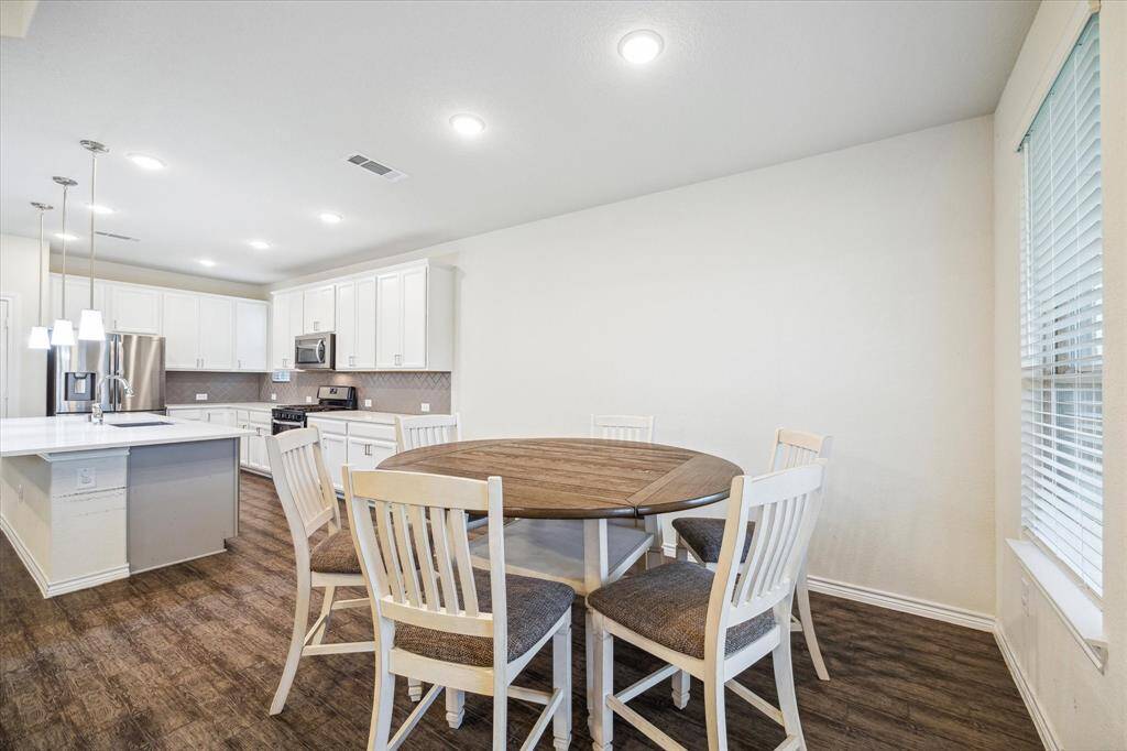 Morning room off kitchen has windows for inviting natural light in and offers a comfortable area that can host quick meals to homework.