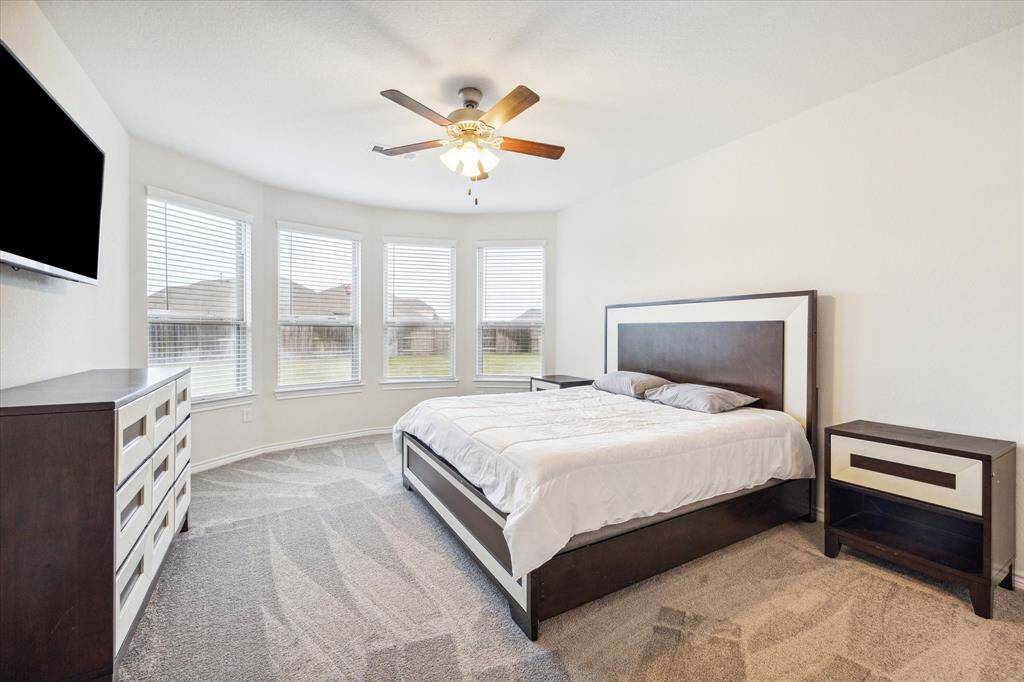 The primary suite is as inviting during daytime as it is after dark . . . The many windows are a key feature, allowing daylight to stream in and illuminate the space during the day. This natural lighting not only enhances the room’s ambiance but also highlights its design elements.