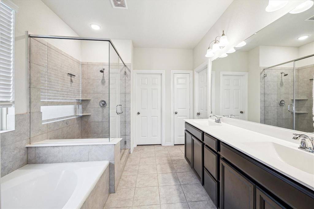 En-Suite Primary Bathroom: Privacy, comfort and convenience! Separate sinks, ample countertops and well-organized storage ease bottlenecks in the primary bath.