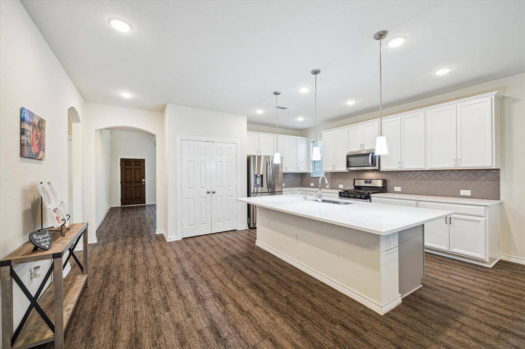 Transitioning from the foyer and living room/flex room, here is a view of the kitchen showing the pantry doors and overall openness of this area.