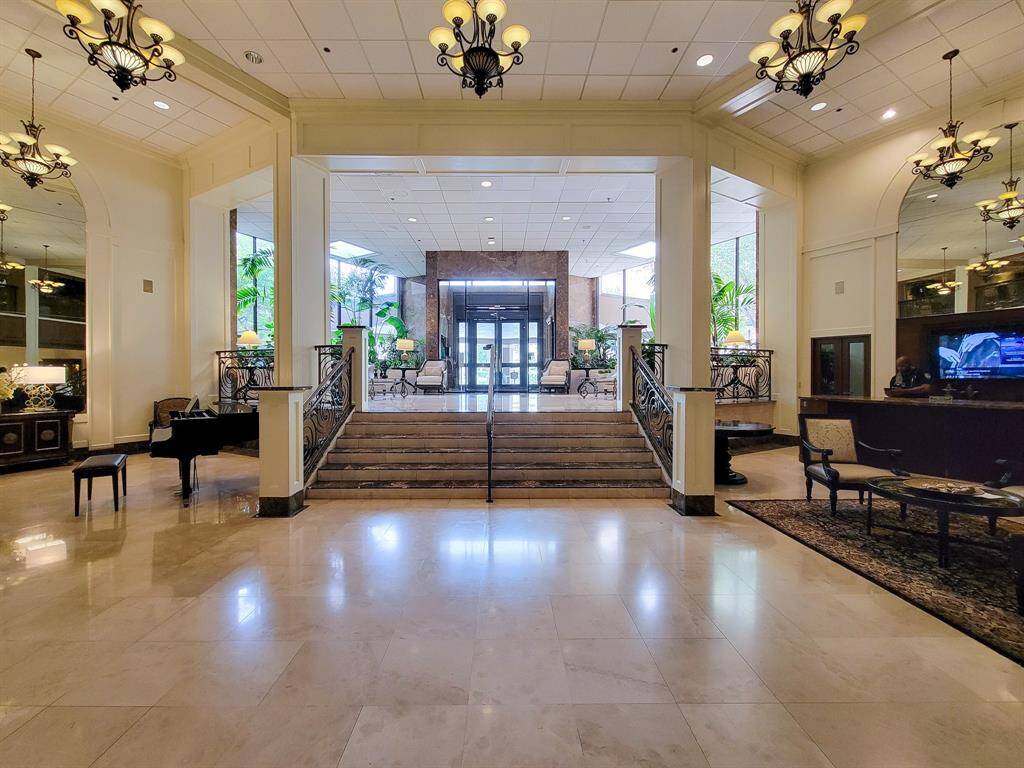 The Lower Lobby features a sleek grand piano, cozy café corner, and stylish seating area.
