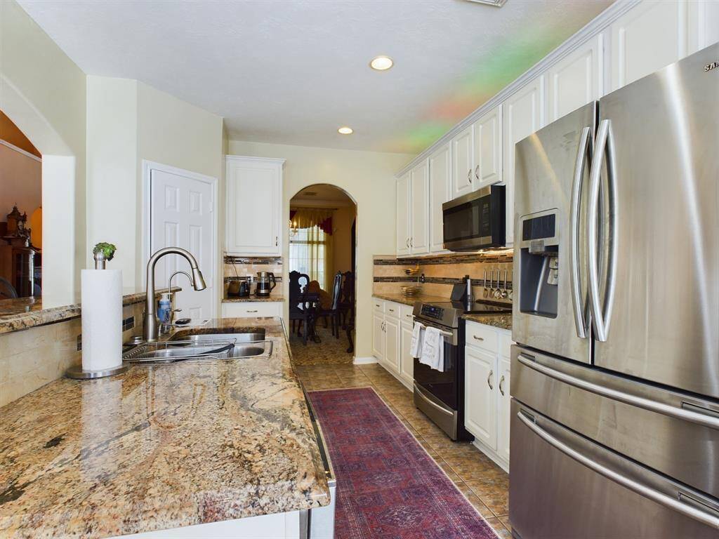 The open layout includes a double sink and granite countertop.