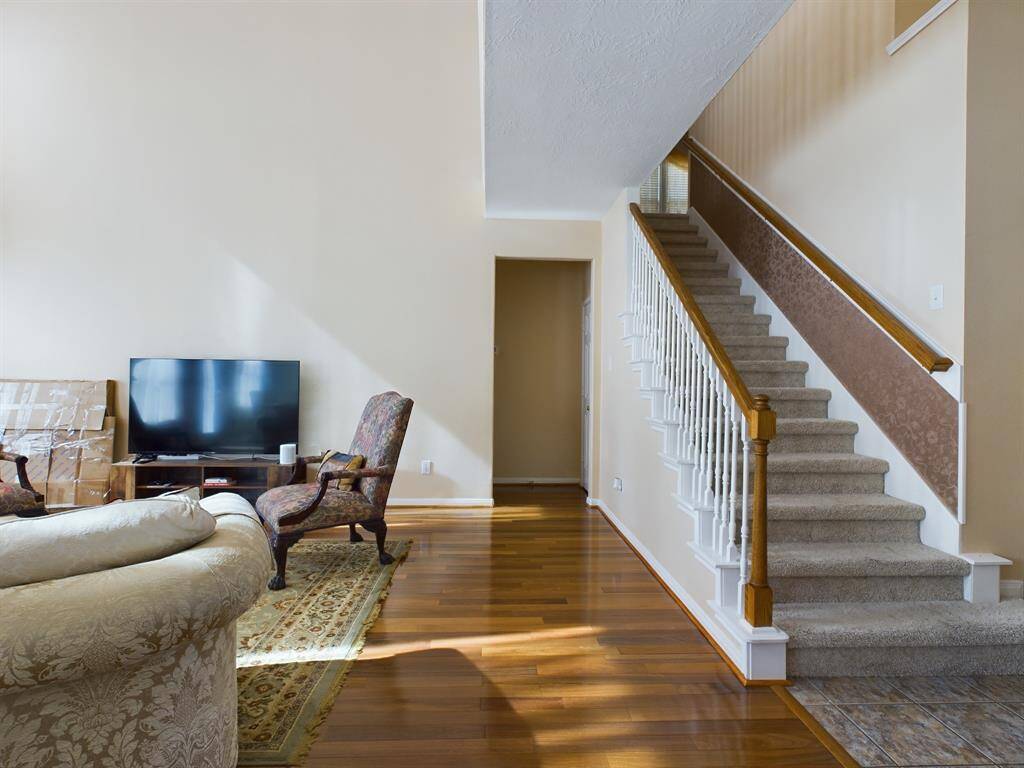 A carpeted staircase with wooden handrails ascends to the upper level