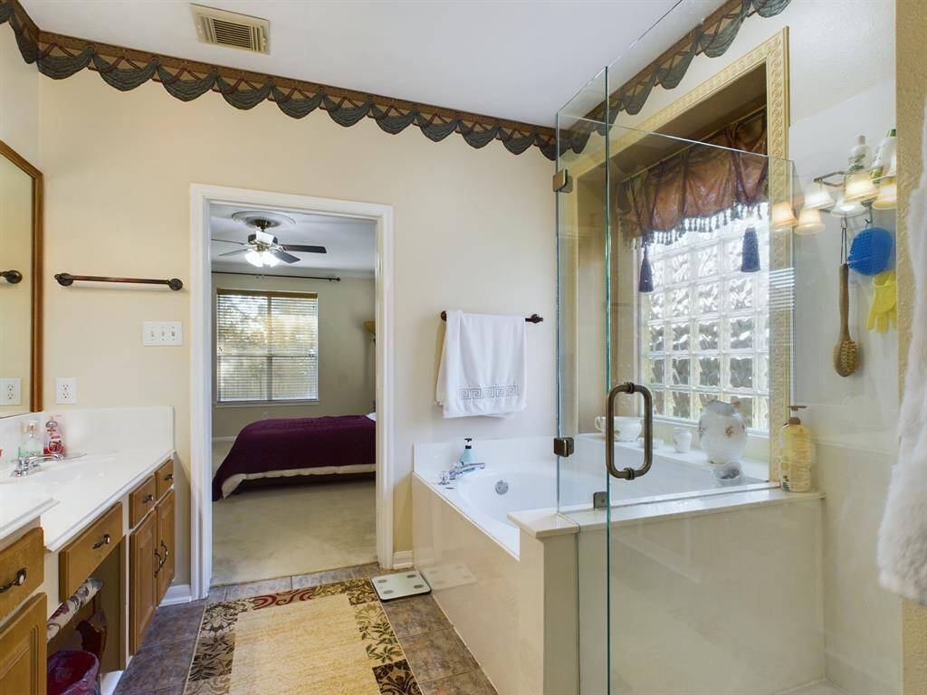 The primary bathroom features a double vanity and a large window allowing ample natural light.
