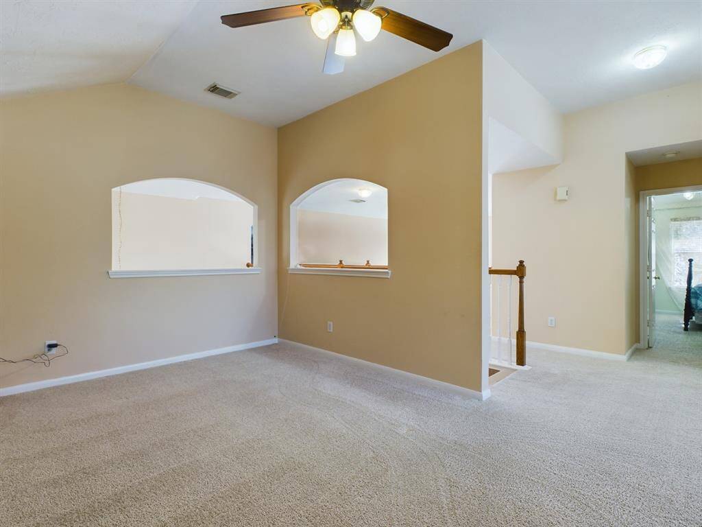 The charming arched wall openings provides views to the downstairs foyer and living room.