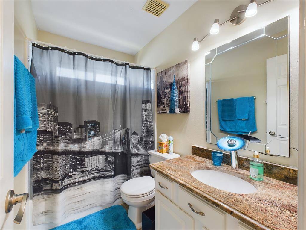 Hall bathroom includes a shower/tub combo and granite countertop