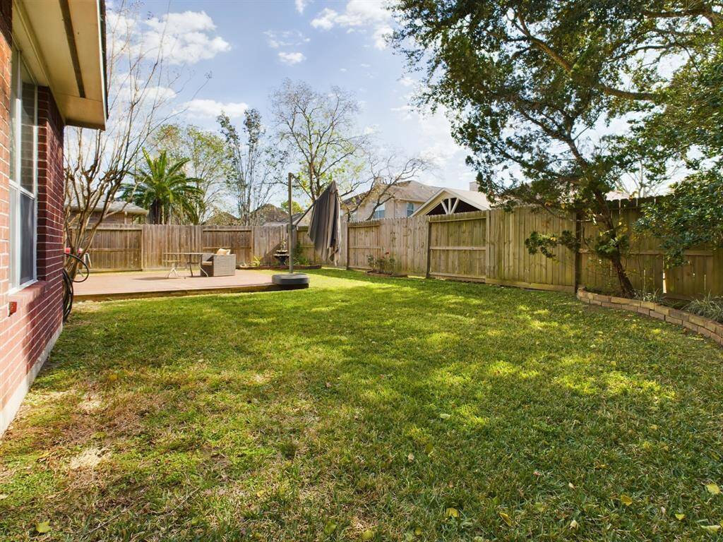 Spacious backyard with a well-maintained lawn and a privacy fence