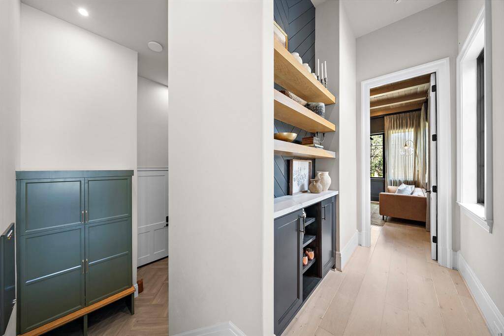 This view showcases the entry from the garage leading up the stairs and the dedicated hallway leading to the study.  Down this hallway is a custom built-in with cabinets and floating shelves.  Perfect for art display!  Not seen in this photo is an exterior door accessing the wrap around front porch.