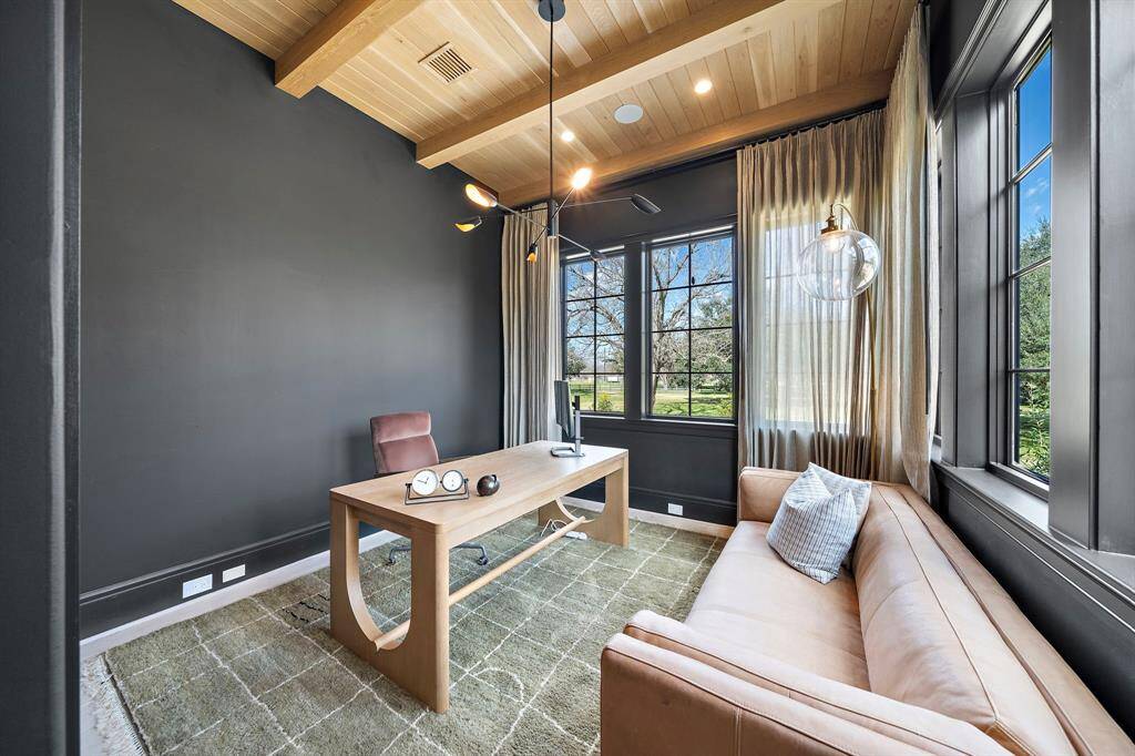Tastefully designed study with dark walls and wood ceiling, pendant lighting and additional recessed lighting, wrap around window and custom window treatments.  As noted before, this space can also serve as an additional downstairs bedroom.