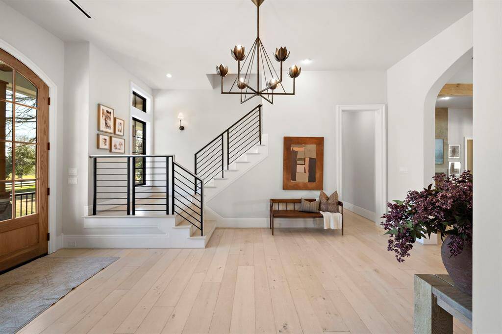 Located in the foyer is a sleek black iron staircase leading you to 3 additional secondary bedrooms and an upstairs game room.