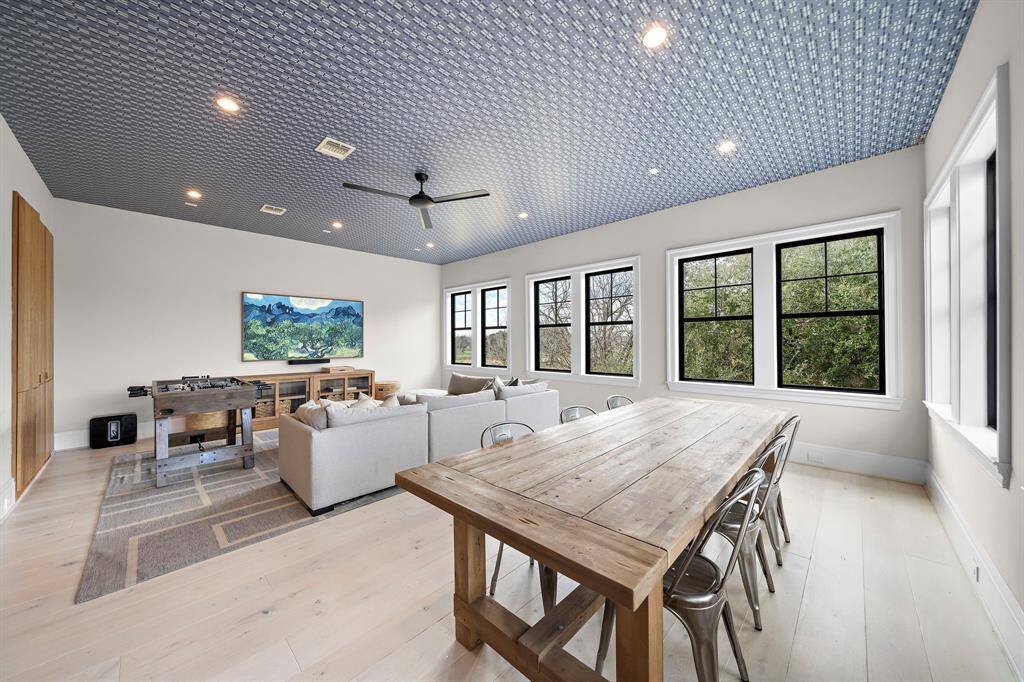 The upstairs game room has custom built-ins with extra-large drawers, a decorative ceiling, and stunning views of the backyard.