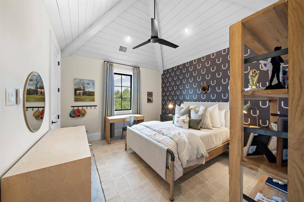 Second bedroom upstairs with an accent wall and wood paneled vaulted ceiling.