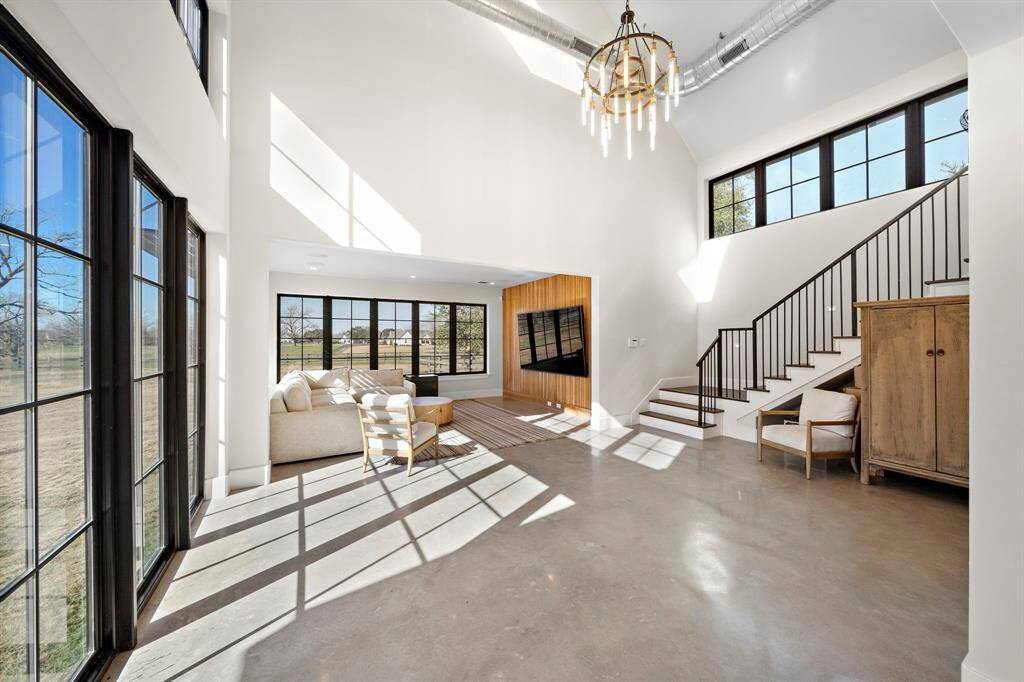 Views of the property abound with windows throughout the downstairs of the Casita. Gorgeous concrete floors, exposed ductwork, stunning chandelier, and a decorative wood wall highlight this space.