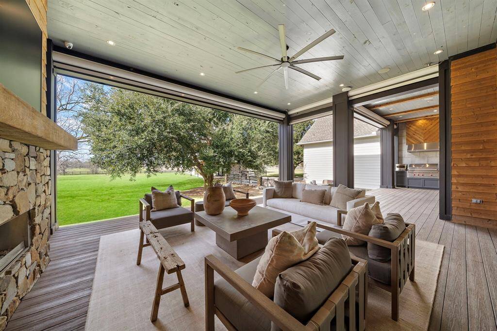 Incredible covered patio overlooking the backyard and lake.  This space along with the summer kitchen can be completely enclosed with automatic roller shades.  Summer kitchen includes a 42" Wolf BBQ Grill.