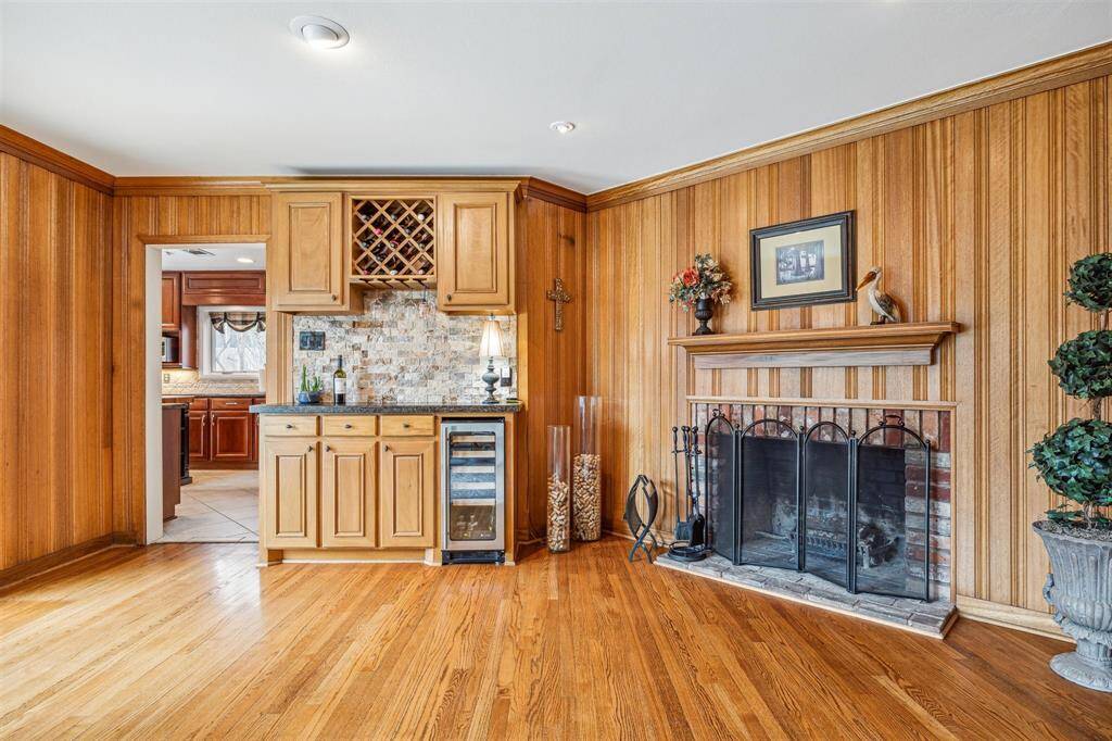 Formal Oak paneled den with floor to ceiling windows and a wood burning fireplace