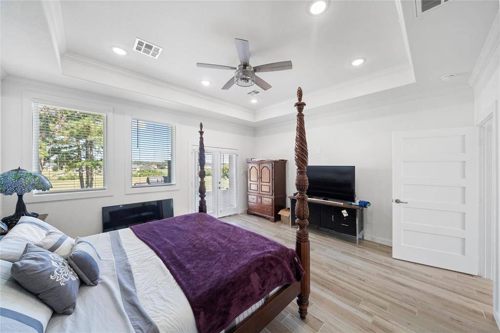 Primary bedroom has nice views to the rear of the property, with doors that lead to the covered back patio.