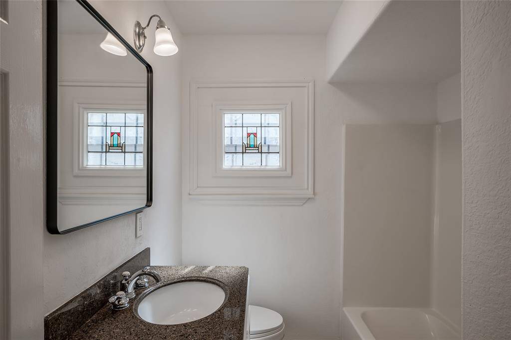 This full bath, with tub and shower combined, is just down the hall from the kitchen and between the 2 bedrooms.