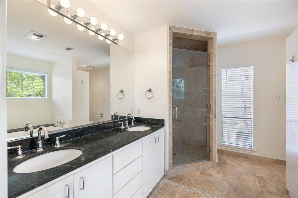 En-suite bath features a granite dual vanity, with walk-in shower and separate tub.