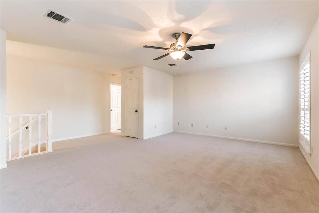 Head up the carpeted staircase from the foyer to this upstairs game room that serves as the nucleus of the second-floor. Here,  you'll find brand-new plush carpet, neutral paint, a lighted ceiling fan, and windows shaded by plantation shutters.