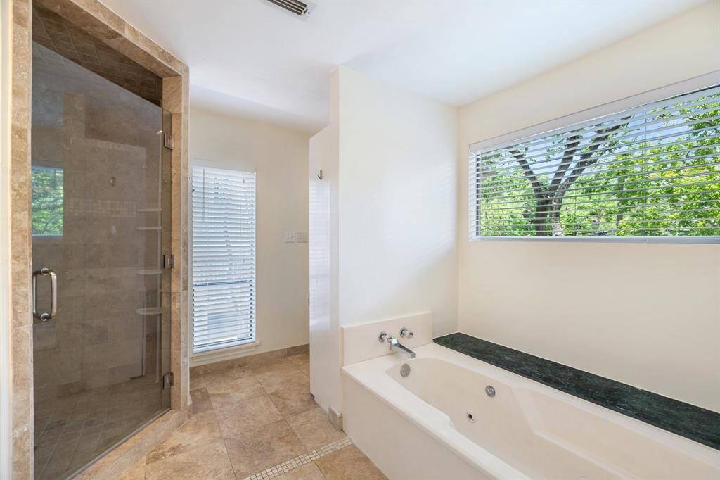 Primary bath has plenty of natural light, as well as a whirlpool tub.