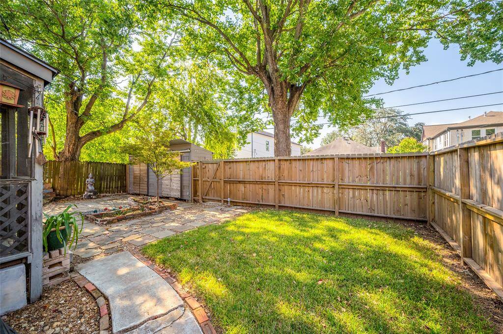Recent fence, beautiful trees, art pieces that stay with the house, and dual storage units in the back yard.