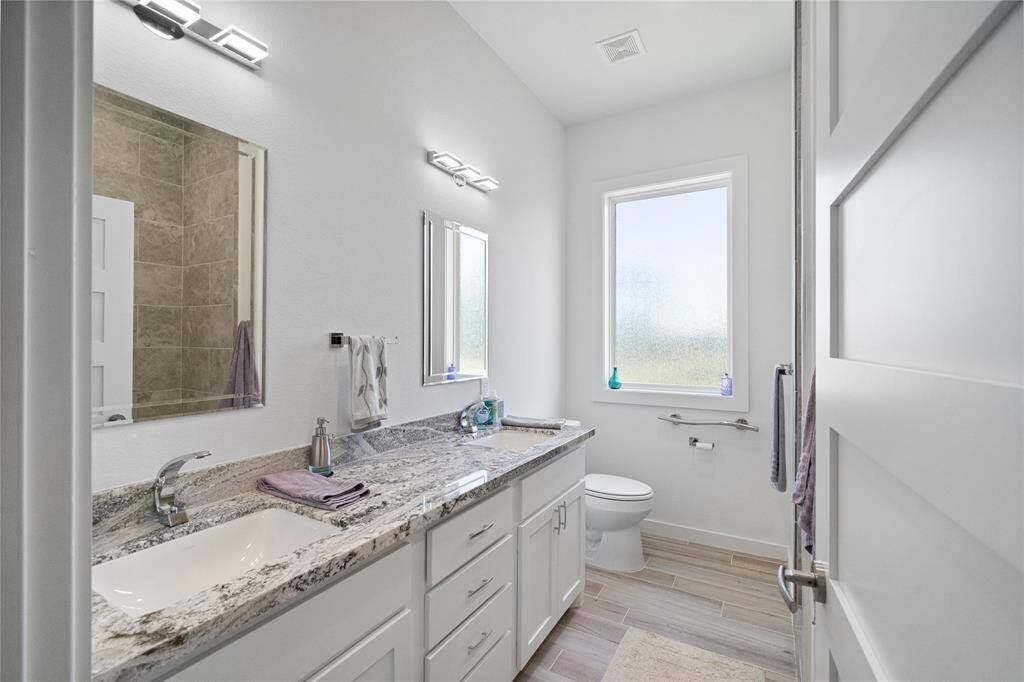 Second full bath has two sinks and granite counters.