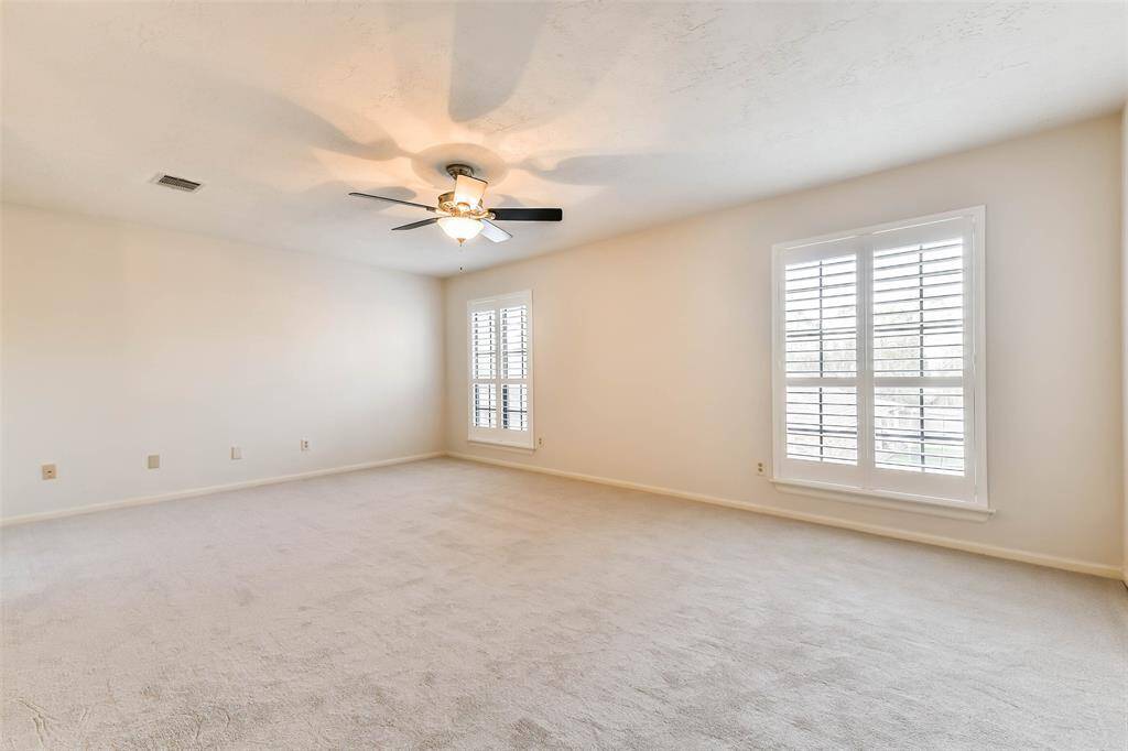 Head up the carpeted staircase from the foyer to this upstairs game room that serves as the nucleus of the second-floor. Here,  you'll find brand-new plush carpet, neutral paint, a lighted ceiling fan, and windows shaded by plantation shutters.