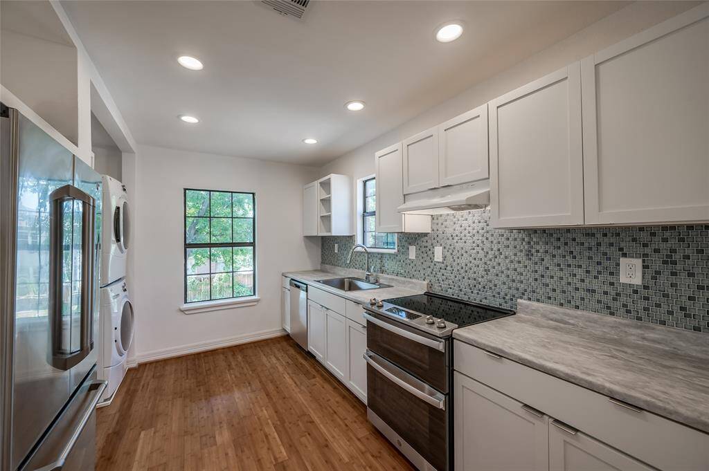 The recently remodeled kitchen has stainless steel appliances including a double oven, side by side refrigerator, dishwasher, new shaker cabinets and Mediterranean blue tile.