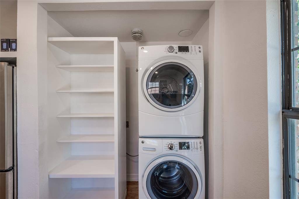 The stackable washer and dryer and storage in the kitchen area.