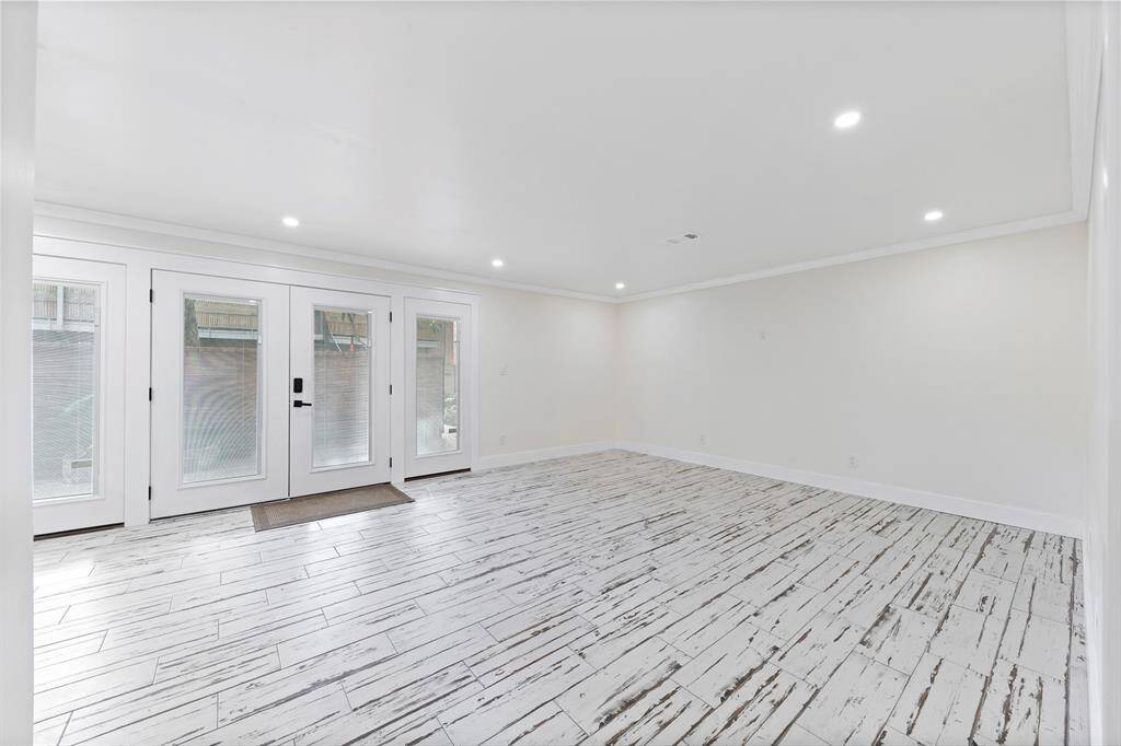 Abundant natural light pours through the elegant French doors and sidelights, creating a bright and welcoming atmosphere throughout the home