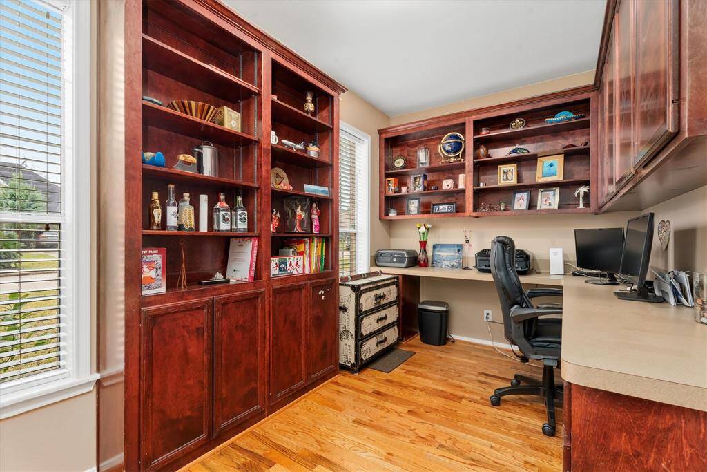 Natural light streams in through the windows, highlighting the warm hardwood floors.