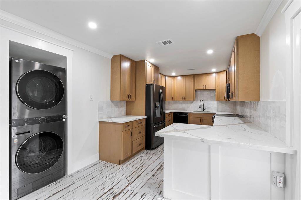 Convenient stackable washer and dryer discreetly located in the kitchen, providing efficient use of space