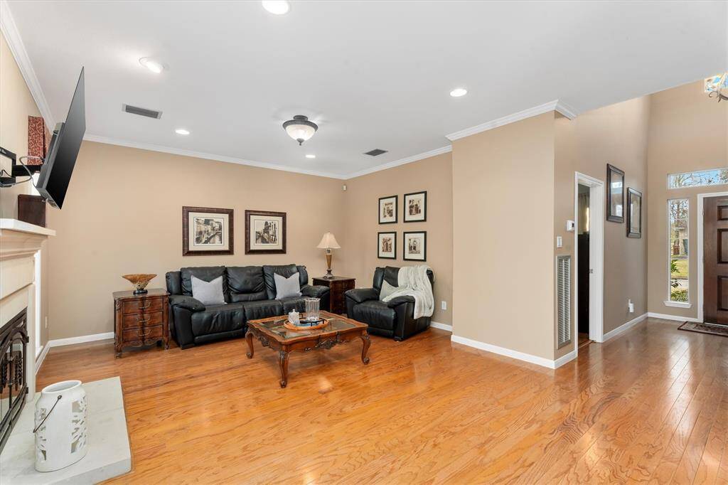 A classic gas log fireplace flanked by 2 windows creates a cozy yet elegant atmosphere in the living room.