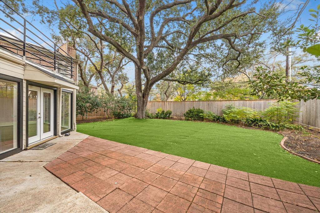 Turfed backyard, with patio seating, accessible from the living area.