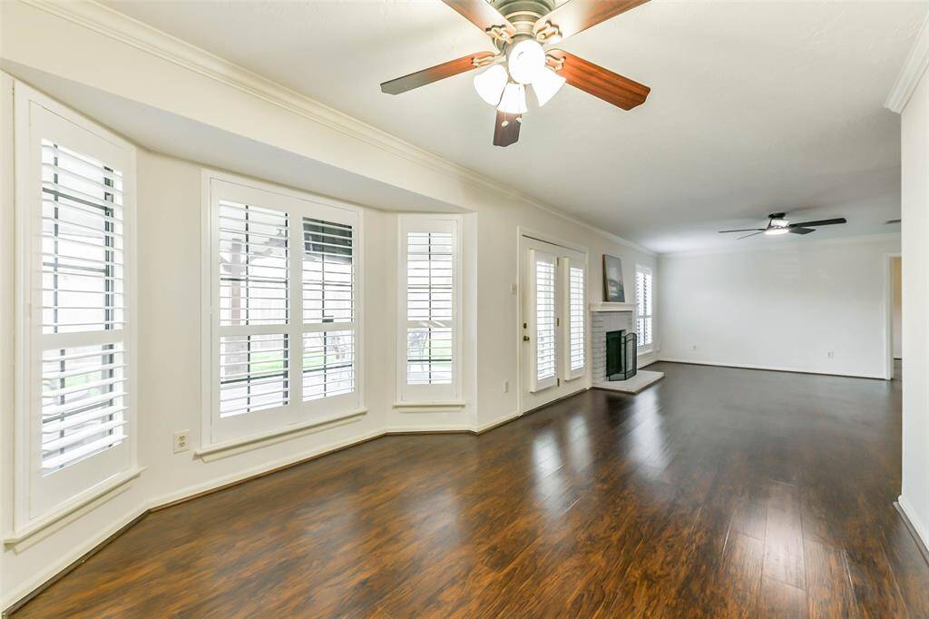 From this vantage point in the family room you can see that the living space spills into a flex-use dining area or study adjacent to the kitchen. Notice the abundance of windows dressed with timeless plantation shutters.