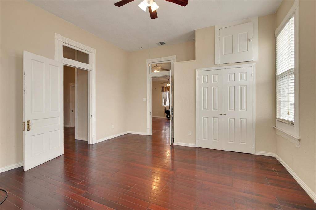 Note the lovely wood floors and transom windows in this large room.