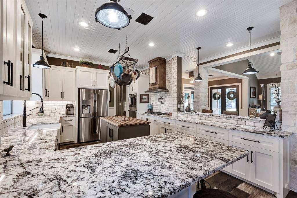 Expansive stone counters, loads of cabinets, butcher block storage island and breakfast bar area.