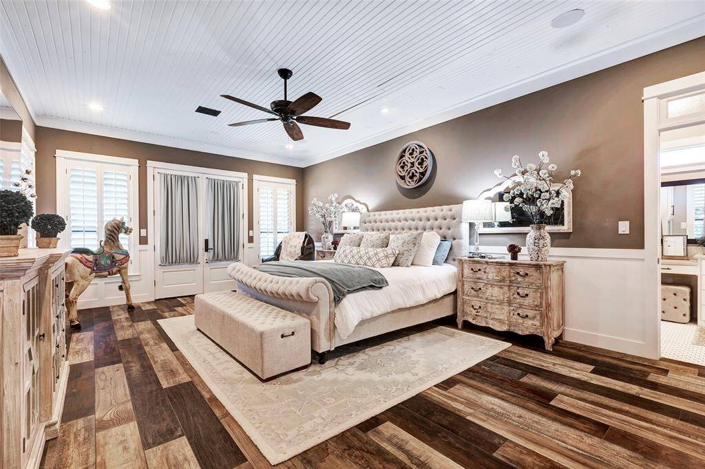 The primary bedroom is surrounded by windows and has double door outdoor access to the pool and back porch