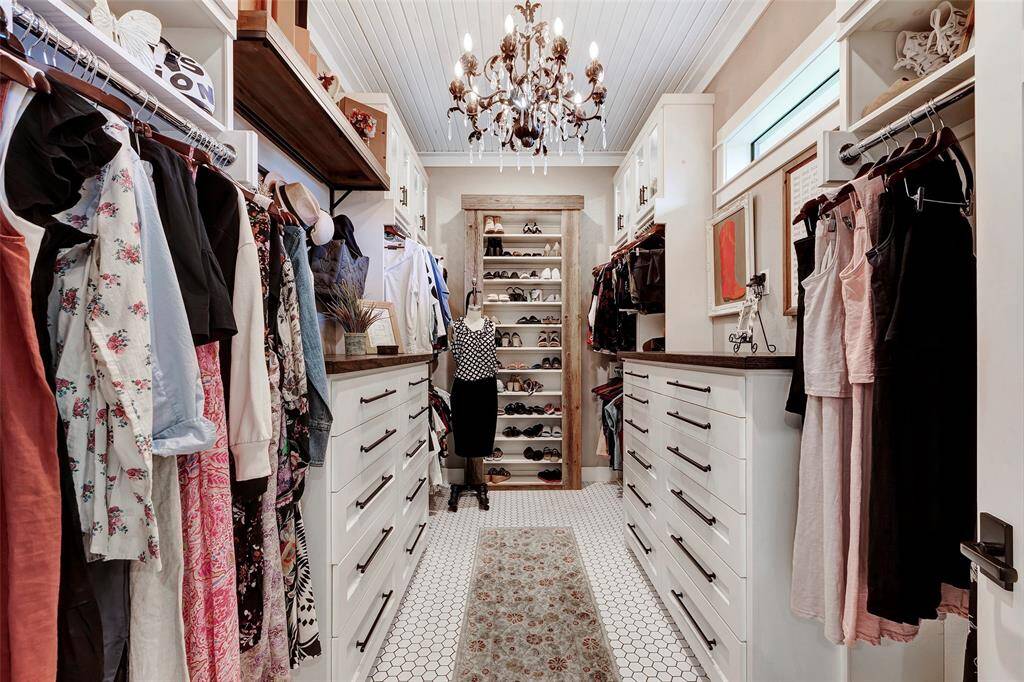 Just one of the 2 primary closets... built in custom dressers & shoe storage and shimmering chandelier