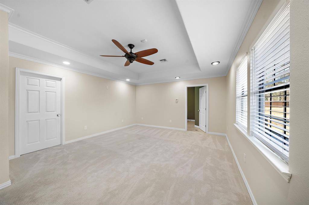 The oversized rimary bedroom features 2 primary closets, crown molding, and an en suite bathroom.