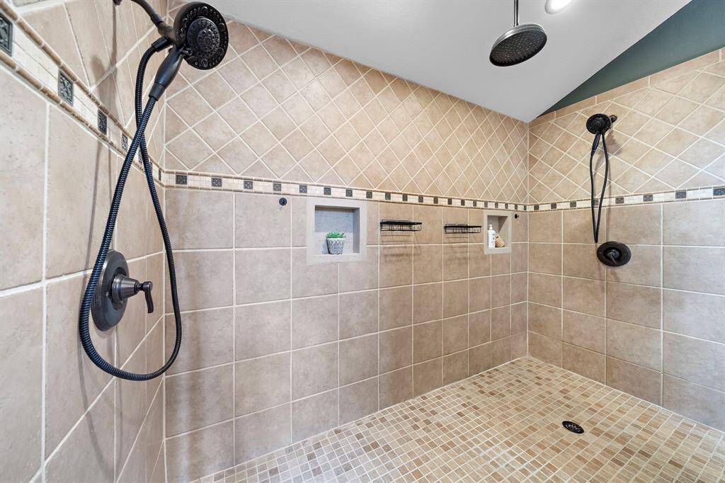 Drive-through primary shower featuring dual hand held shower heads and a rain shower.
